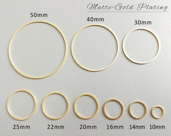 May include: Matte gold plated jump rings in various sizes, ranging from 10mm to 50mm in diameter.  The jump rings are arranged in order of size, with the smallest ring on the right and the largest ring on the left.