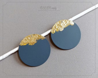 May include: A pair of round earrings with a dark blue background and a gold accent on the top half of each earring.