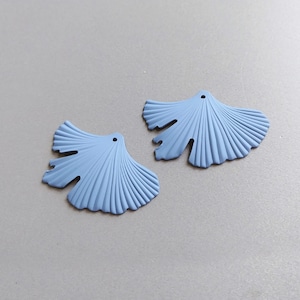 May include: Two light blue ginkgo leaf shaped metal charms with a hole at the top for hanging.