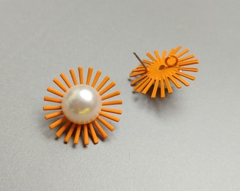 May include: A pair of orange flower-shaped earrings with a white pearl in the center. The earrings have a simple design and are perfect for everyday wear.