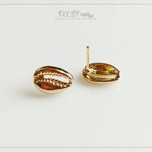 May include: A pair of gold-tone shell-shaped stud earrings. The earrings are made of metal and have a smooth, polished finish.