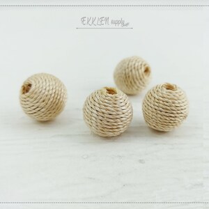 May include: Four natural beige round rope beads. The beads are made of woven rope and have a slightly textured surface.