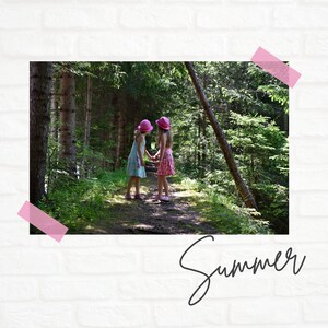 May include: Two girls wearing pink hats and dresses walk hand-in-hand on a path through a forest. The path is lined with green trees and foliage.