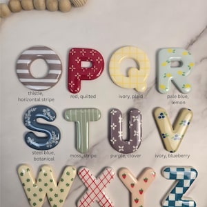 May include: A collection of twelve decorative letters from O to Z, each featuring unique patterns and colours including striped, quilted, plaid, lemon, botanical, clover, blueberry, ditsy floral, cross hatch, strawberry, and checker designs.