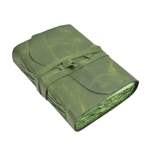 May include: A green leather journal with a strap closure. The journal has a textured cover and visible stitching along the spine. The pages are visible and have a rough, uneven edge. The journal is rectangular and appears to be handmade.