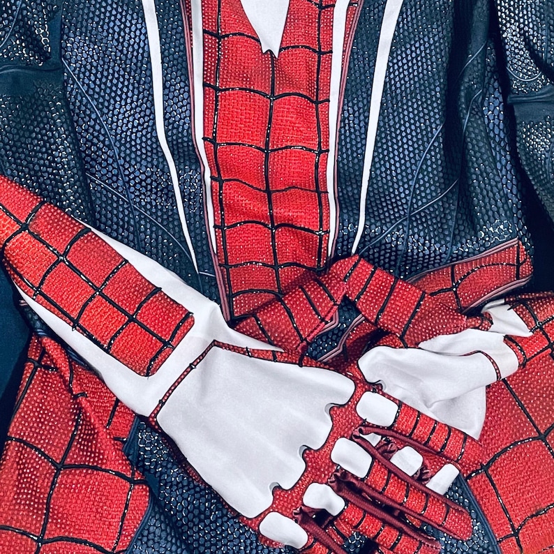 May include: A red and black Spider-Man costume with a web pattern. The costume features a red torso and arms with a black web design. The gloves are white with red accents. The suit is made of a shiny material.