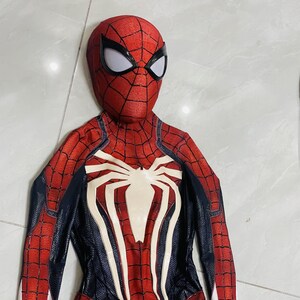 May include: A red and black Spider-Man costume with a white spider emblem on the chest. The costume features a web pattern and a mask with white eye lenses. The suit is designed to resemble the superhero's iconic look.