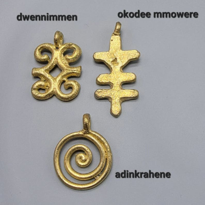 May include: Three gold-colored pendants with different designs. The first pendant is a stylized symbol called "dwennimmen". The second pendant is a stylized symbol called "okodee mmowere". The third pendant is a stylized symbol called "adinkrahene".