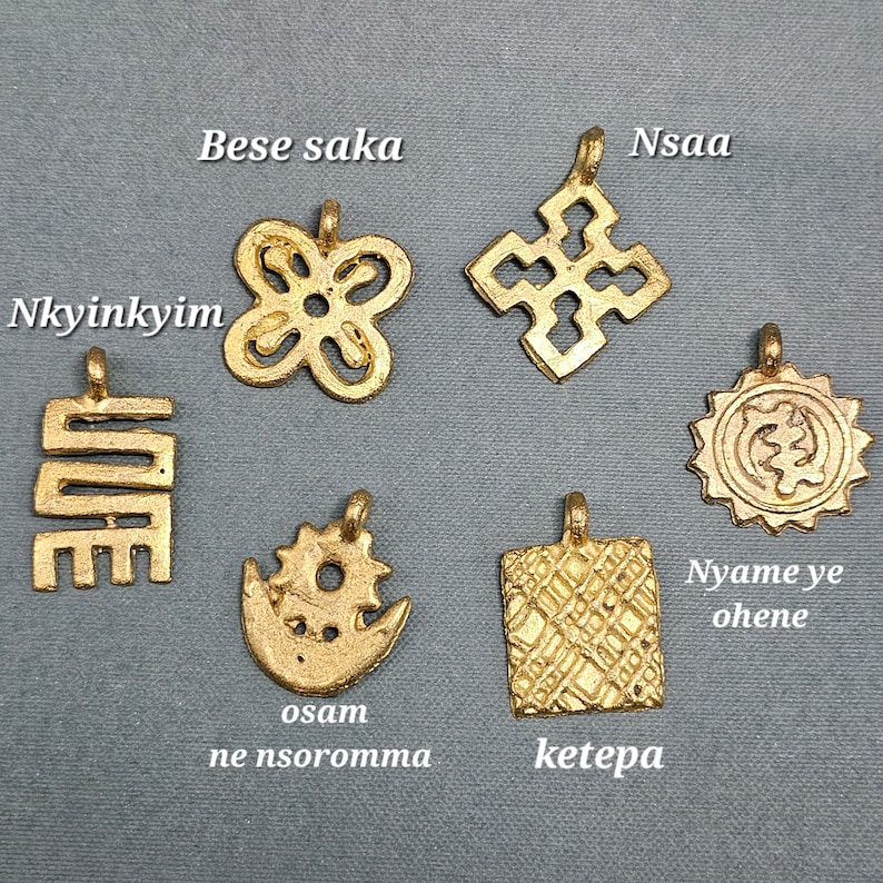 May include: Seven gold-colored pendants with different designs and symbols. The pendants are labeled with the words "Nkyinkyim", "Bese saka", "Nsaa", "Osam ne nsoromma", "Ketepa", and "Nyame ye ohene".