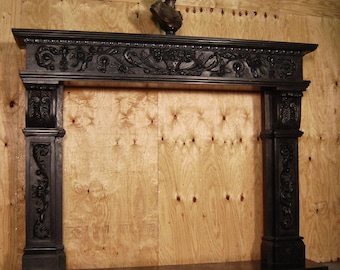 May include: A dark, ornate fireplace mantel with intricate carvings and a bronze bust on top. The mantel features floral and scrollwork designs, with detailed columns on either side. The overall style is classic and elegant, suitable for a traditional home.