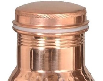 May include: A copper water bottle with a hammered texture and a matching screw-on lid. The bottle has a cylindrical shape and is made of shiny, reddish-brown metal. The bottle is designed to hold liquids.