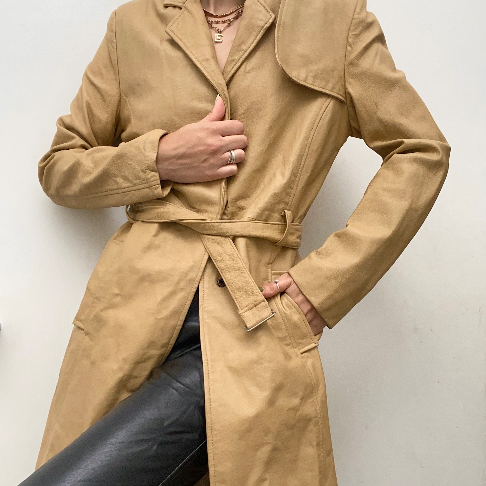 Vintage 90s beige trench coat. Real leather. Tie and press studs to fasten. A high quality vintage piece. UK Size 8. Slim fit. Our model is 5.4 foot and usually wears a UK Size 6/8.