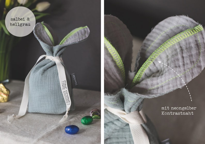 Puede incluir: Una bolsa de conejo de tela azul claro con una cinta blanca y una etiqueta que dice "Frohe Ostern!" La bolsa tiene costuras de color amarillo ne&oacute;n alrededor de las orejas.