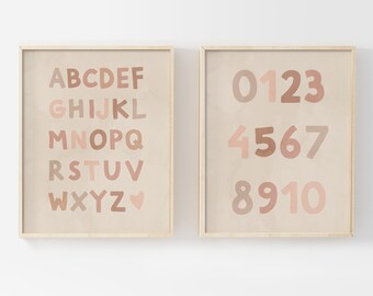 May include: Two framed prints with a beige background. The left print features the alphabet in a colorful, hand-drawn font. The right print features the numbers 0-10 in a colorful, hand-drawn font.