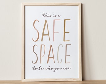 Könnte beinhalten: Ein gerahmter Druck mit dem Text "This is a safe space to be who you are." Der Text ist in handschriftlicher Form und in Brauntönen, Rosa und Beige gehalten.