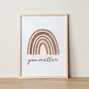 May include: A framed print with a watercolor rainbow in shades of brown and beige. The rainbow is arched over the text "you matter".