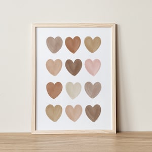 May include: A framed print with a white background and 12 brown, beige, and pink watercolor hearts arranged in a grid pattern.