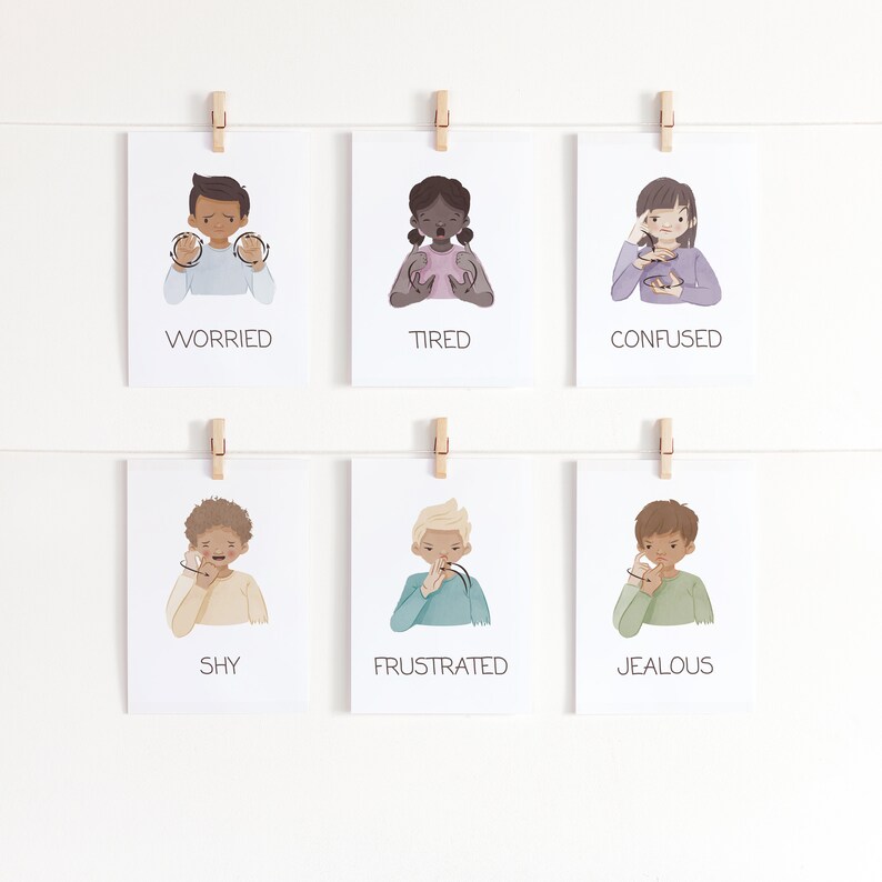 May include: Six white cards with illustrations of children expressing emotions, including worried, tired, confused, shy, frustrated, and jealous. Each card is labeled with the corresponding emotion in black text and held by a wooden clothespin.