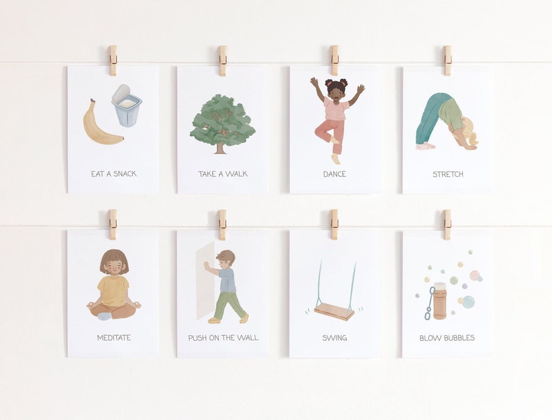 May include: Eight illustrated cards with different activities for kids. The cards are hung on a white wall with wooden clothespins. The activities include eating a snack, taking a walk, dancing, stretching, meditating, pushing on the wall, swinging, and blowing bubbles.