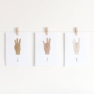 May include: Three cards with hand gestures, each card has a different skin tone. The cards are numbered 6, 7, and 8.