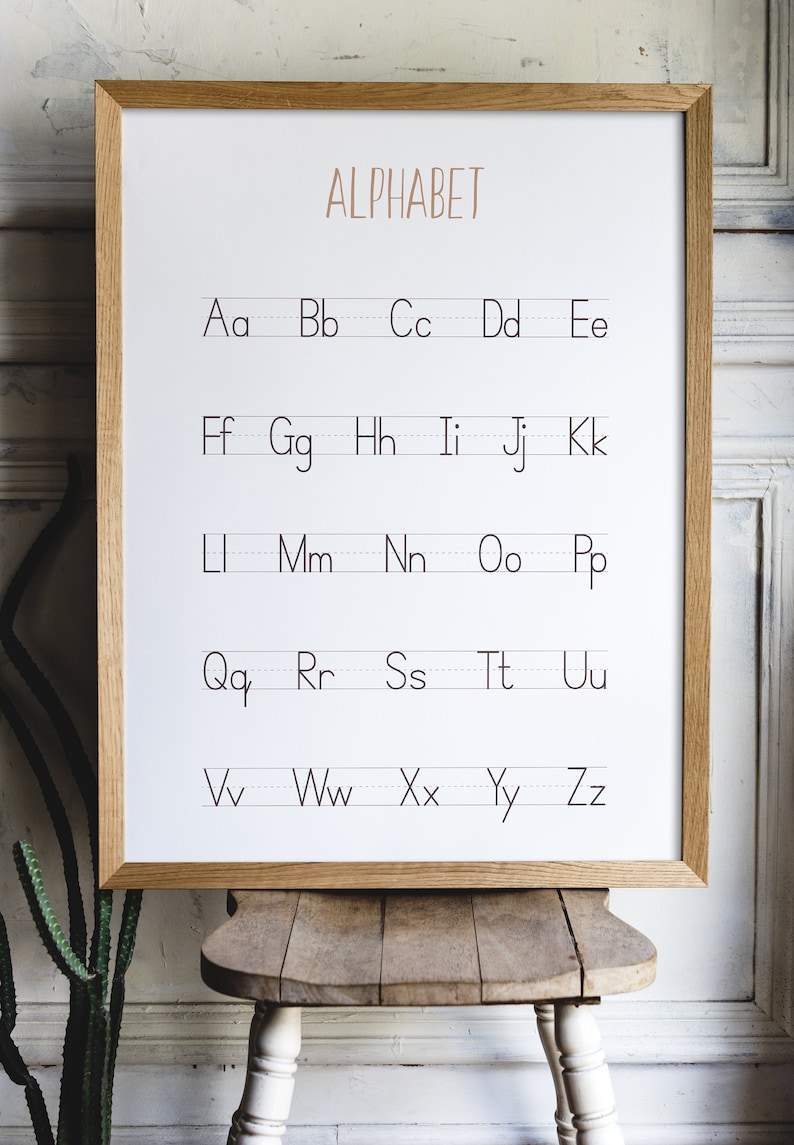 Peut inclure: Un tableau d'alphabet encadr&eacute; blanc avec le mot "ALPHABET" imprim&eacute; en brun en haut. Les lettres de l'alphabet sont imprim&eacute;es en noir avec une ligne sous chaque lettre.