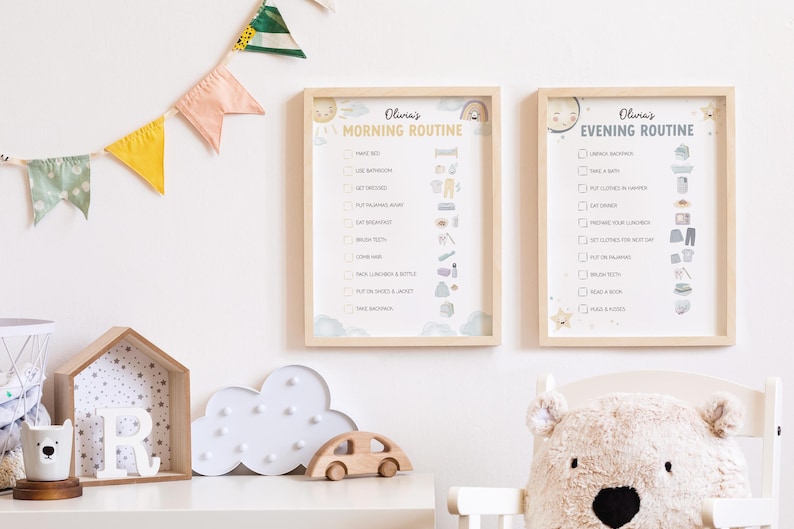 May include: Two framed children's routine charts, one for morning and one for evening, with a light wood frame. The charts have a soft, pastel color scheme with illustrations. A wooden car, cloud-shaped light, and bear-shaped pillow are on a white shelf.