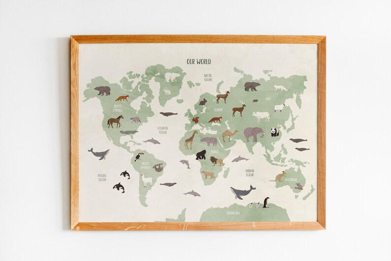 K&ouml;nnte beinhalten: Eine gerahmte Weltkarte mit einem gr&uuml;nen und beigen Farbschema. Die Karte zeigt Illustrationen von Tieren, die auf verschiedenen Kontinenten beheimatet sind, darunter ein Eisb&auml;r, eine Giraffe, ein K&auml;nguru und ein Pinguin. Der Text "OUR WORLD" ist oben auf der Karte gedruckt.