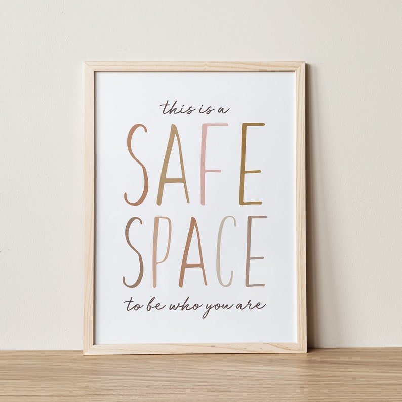 May include: A framed print with the text "This is a safe space to be who you are." The words "safe" and "space" are in large, colorful letters.