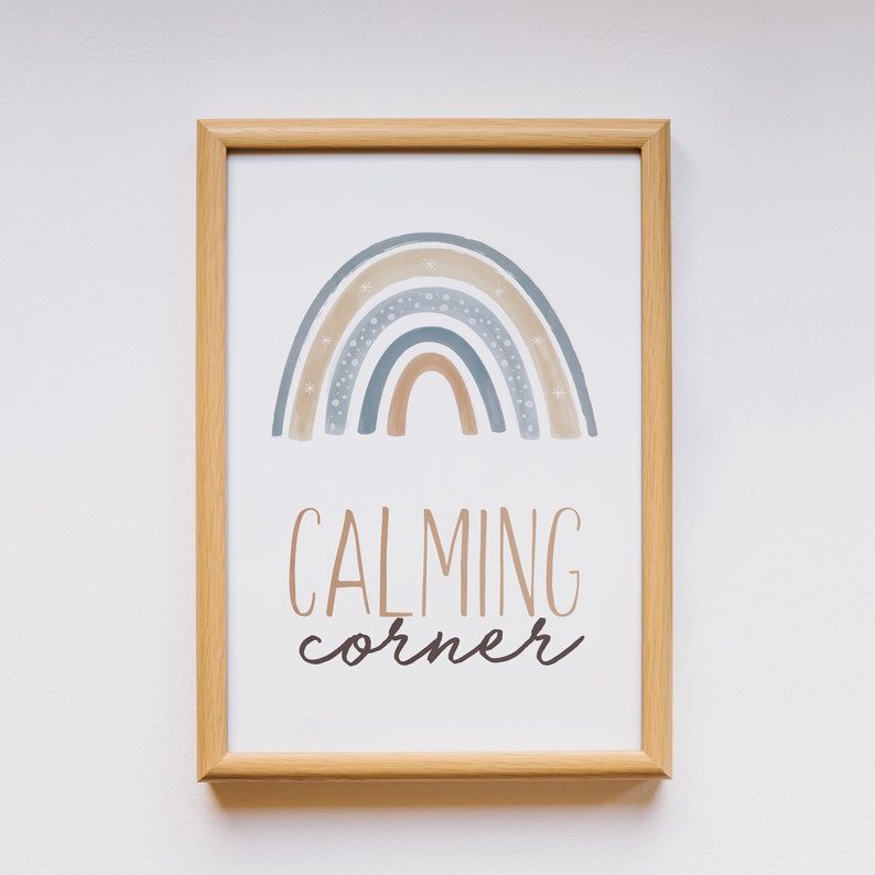May include: A framed print with a watercolor rainbow in shades of blue, brown, and beige with white stars. The text "CALMING corner" is written below the rainbow.