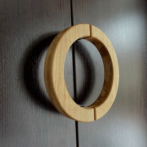 May include: A round wooden door handle with a natural wood finish.