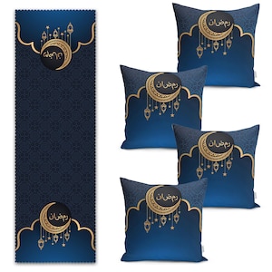 Puede incluir: Cuatro cojines decorativos azules con detalles dorados y la palabra árabe "Ramadán" en una fuente decorativa. Los cojines tienen un diseño de media luna y estrellas. El fondo es una tela azul oscuro con estampado.