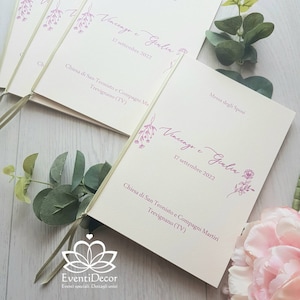 Può includere: Un programma per la cerimonia di matrimonio con un design floreale e i nomi Vincenzo e Giulia, la data 17 settembre 2022 e la location Chiesa di San Teonisto e Compagni Martiri, Trevignano (TV). Il programma è legato con un nastro dorato.