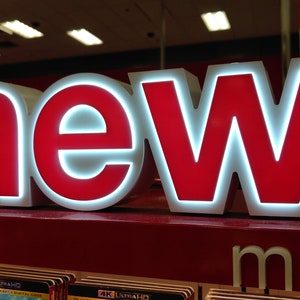 May include: A red and white sign with the word "new" in large, bold letters. The sign is lit up with white lights.