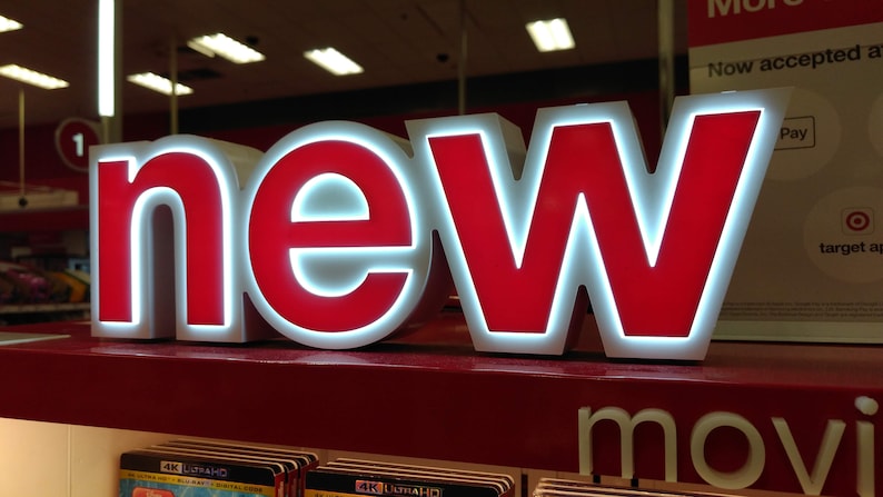 May include: A red and white sign with the word "new" in large, bold letters. The sign is lit up with white lights.