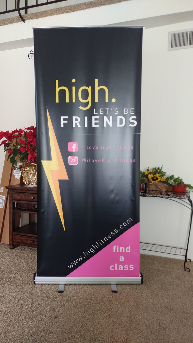 May include: Black and pink retractable banner with the text "high. LET'S BE FRIENDS" and a yellow lightning bolt. The banner also includes the text "www.highfitness.com" and "find a class".