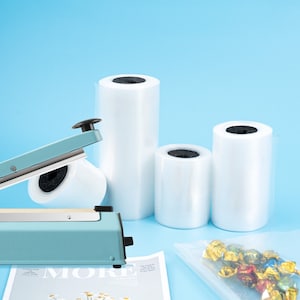 May include: A blue heat sealer with a black handle and a roll of clear plastic wrap. There are three rolls of clear plastic wrap in different sizes.