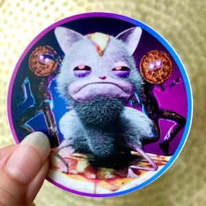 May include: A sticker featuring a purple, furry creature with large eyes and a pizza slice. The creature is surrounded by two black figures with pizza slices for heads.