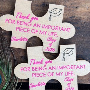 May include: A white ceramic mug with a black handle and the text "But First, Coffee" in a bold, black font. The mug is filled with a dark liquid, likely coffee, and sits on a light-colored surface.