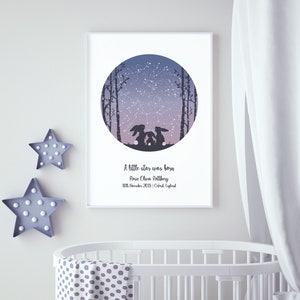 May include: A white framed print with a purple and blue night sky with stars and a constellation. The print features two silhouetted rabbits looking up at the sky. The text reads "A little star was born, Rosie Olivia Rothbury, 10th November 2018 | Oxford, England".