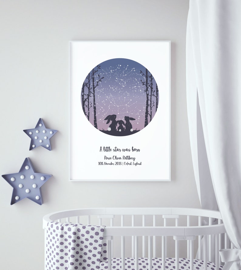 May include: A white framed print with a purple and blue night sky with stars and a constellation. The print features two silhouetted rabbits looking up at the sky. The text reads "A little star was born, Rosie Olivia Rothbury, 10th November 2018 | Oxford, England".