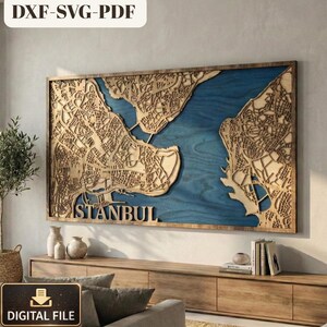 Può includere: Una mappa in legno di Istanbul, con dettagli intricati tagliati al laser delle strade e degli edifici della città. La mappa ha uno sfondo blu e una cornice in legno. La parola "ISTANBUL" è in basso. L'angolo in alto a sinistra recita "DXF-SVG-PDF".