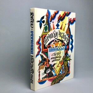 May include: A vintage book cover with a colorful illustration of a puppet show. The title of the book is "Приключения Пиноккио" and the subtitle is "Сказки итальянских писателей".