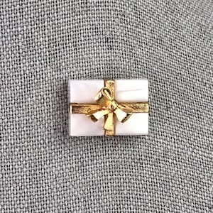 Pin vintage de caja de regalo de Avon: cinta dorada, plástico blanco perlado