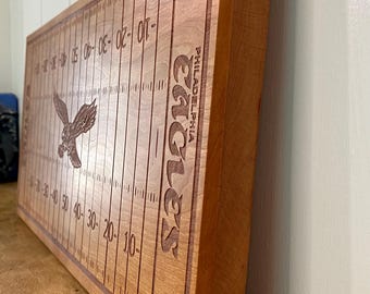 May include: A wooden cutting board with a football field design and the words "Philadelphia Eagles" engraved on it. The board is brown and has a natural wood finish.