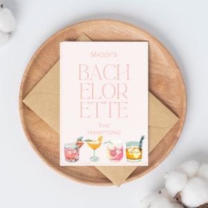 K&ouml;nnte beinhalten: Eine rosa und wei&szlig;e Karte mit dem Text "Maddy's Bachelorette The Hamptons" und einer Grafik von vier Cocktails.