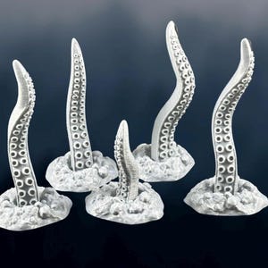 May include: Five silver-coloured tentacle-shaped figurines, each with a textured surface, are arranged on a grey background. The tentacles are all different sizes and shapes, and they are all pointing upwards.