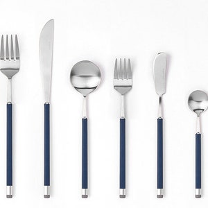 May include: A set of silver cutlery with blue handles, including a knife, fork, spoon, and chopsticks.