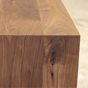 Pode incluir: Close-up de um tampo de mesa de madeira com acabamento de gr&atilde;o de madeira natural. O tampo da mesa &eacute; feito de madeira maci&ccedil;a e tem uma superf&iacute;cie lisa e polida.