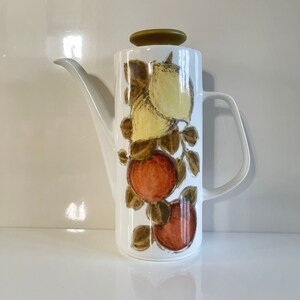 May include: White ceramic coffee pot with a green lid and a design of lemons and oranges on the side.