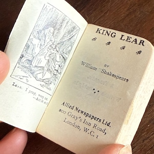 May include: A small, vintage book with a black and white illustration of King Lear on the cover. The title "King Lear" is printed in bold, black letters on the front cover. The book is by William Shakespeare and published by Allied Newspapers Ltd. in London.